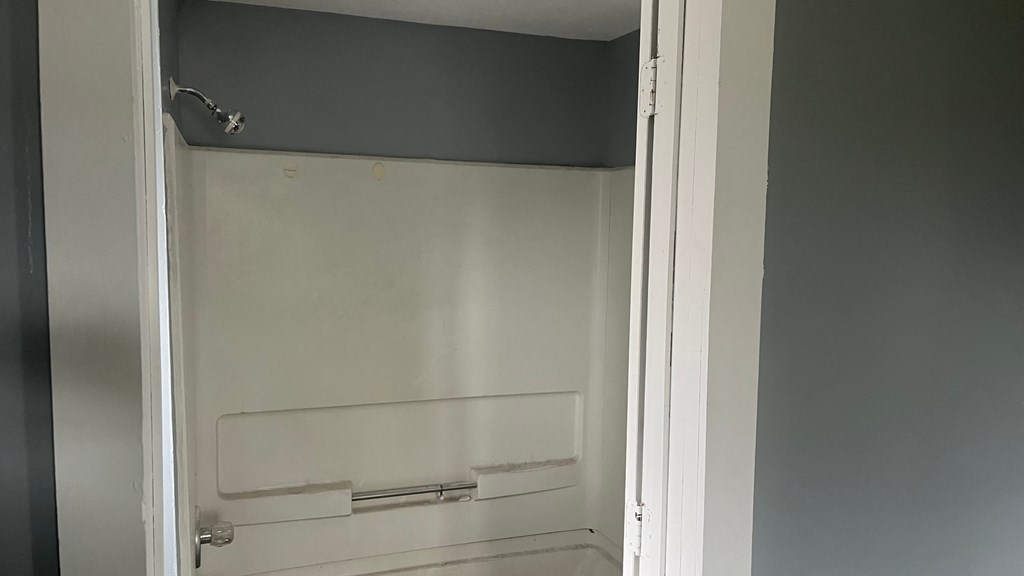 the inside of a small bathroom with an empty shower stall