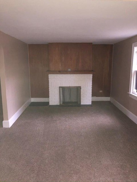 an empty living room with a fireplace