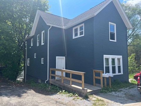 A blue house with a white door and windows.