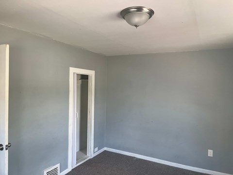 A room with a ceiling light and a door.