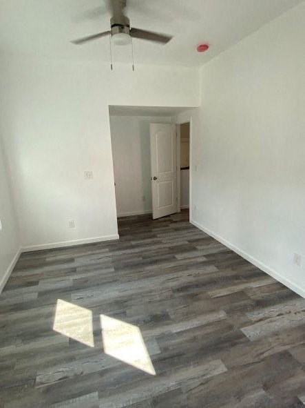 an empty living room with white walls and a ceiling fan