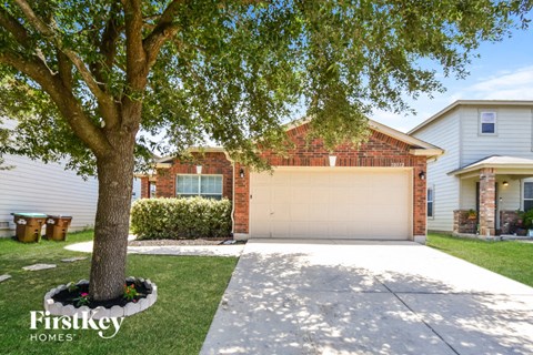 a house with a garage door and a tree in front of it