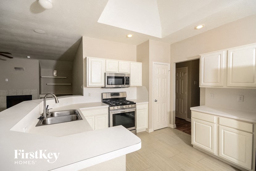 a large kitchen with white cabinets and a sink