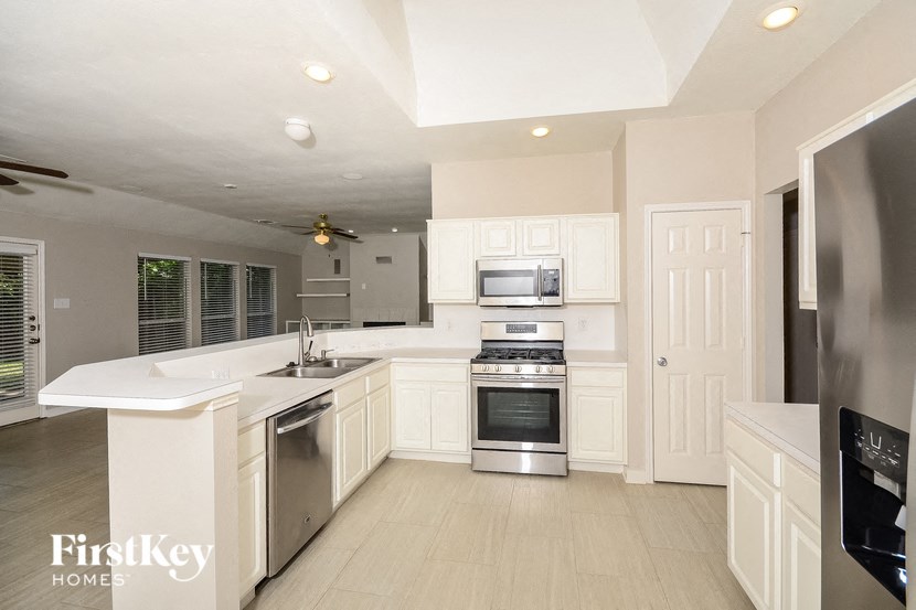 a large kitchen with white cabinets and stainless steel appliances