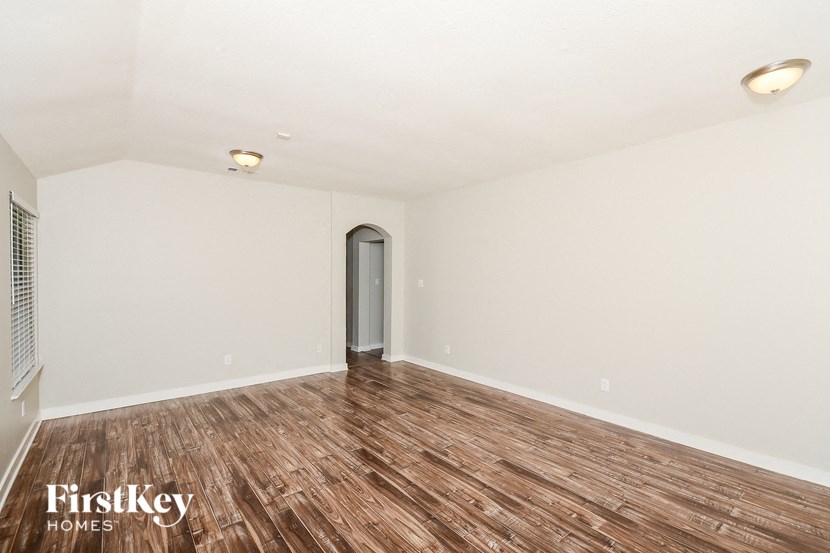 a living room with a hard wood floor and white walls