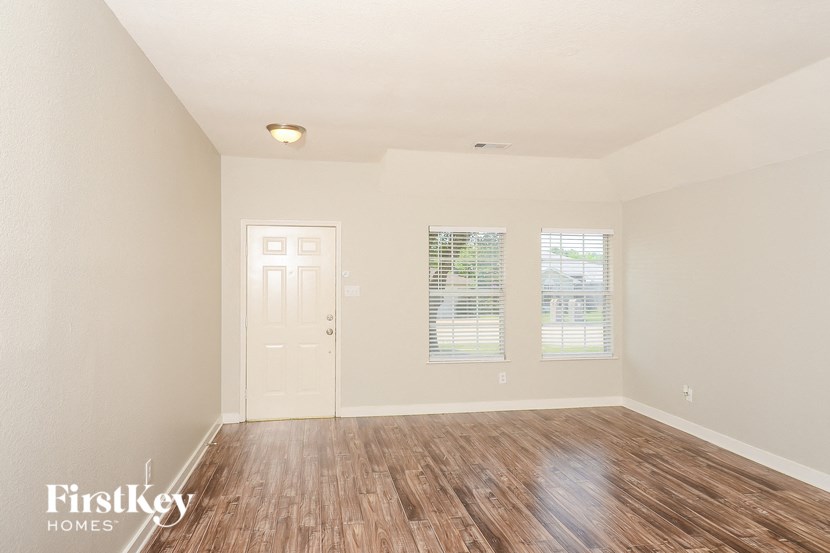 an empty living room with a wooden floor and a white door