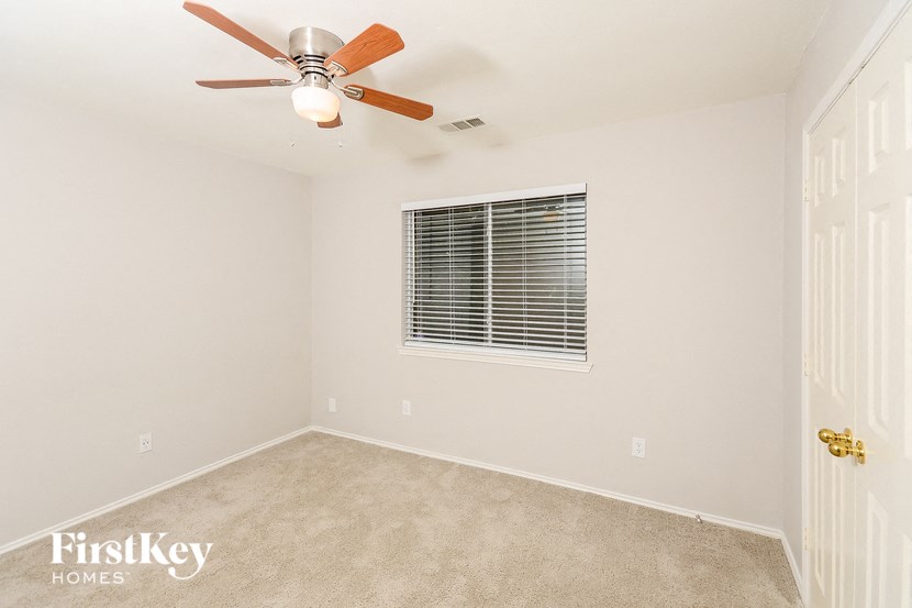 a bedroom with a ceiling fan and a window