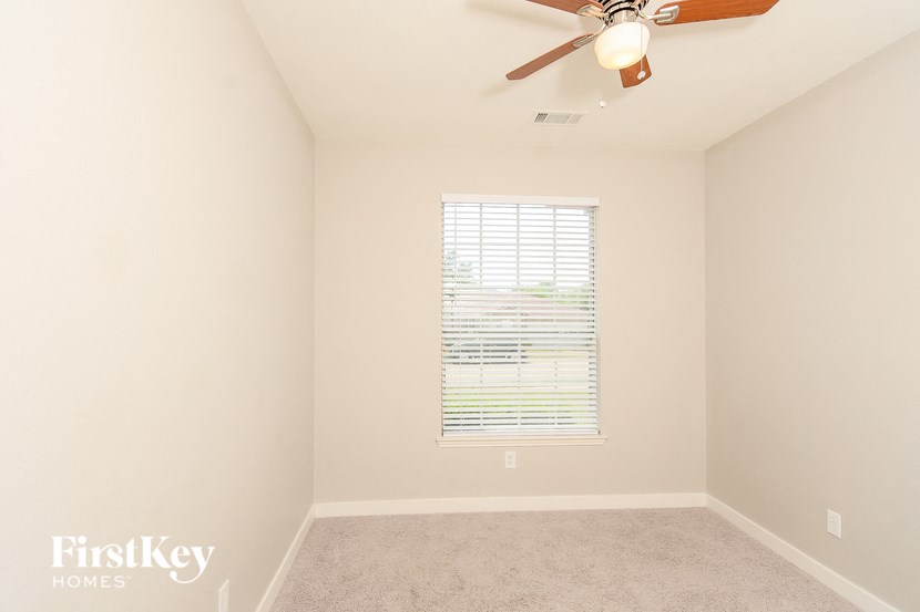 a bedroom with a ceiling fan and a window
