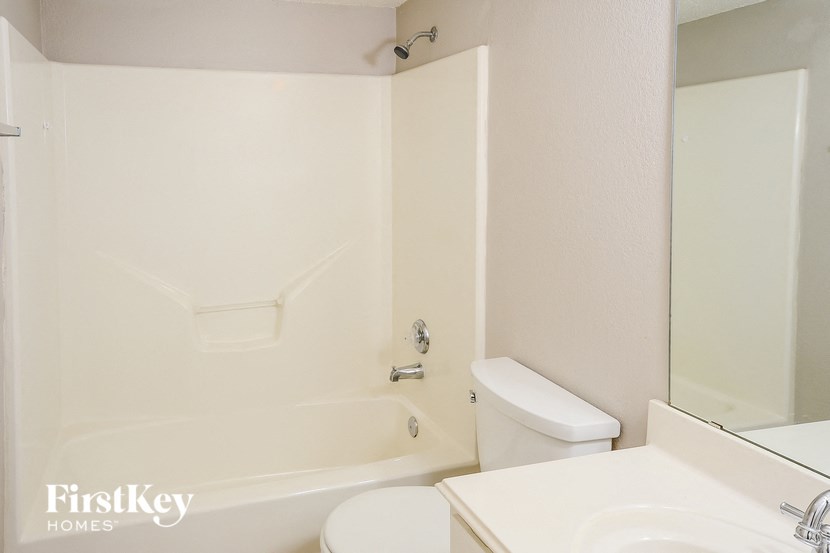 a white bathroom with a toilet and a tub and a sink