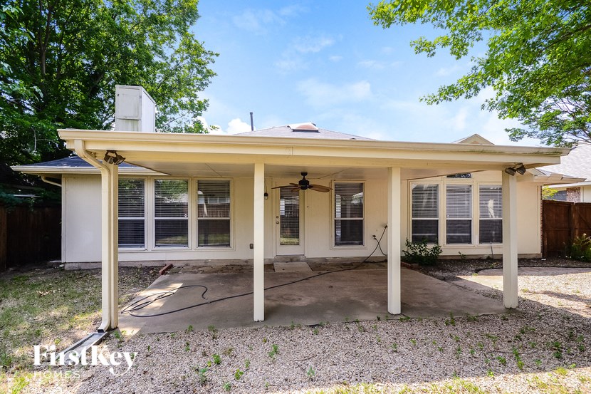 the front of a white house with a covered porch
