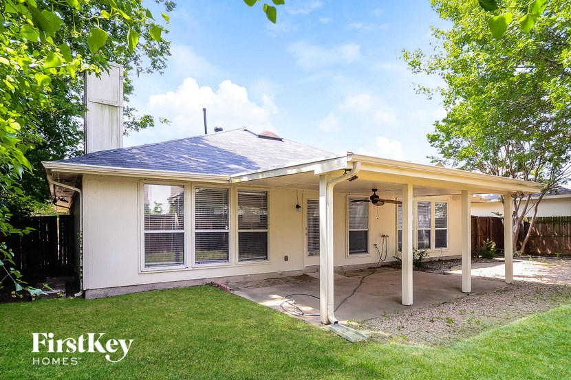a small white house with a porch and a lawn