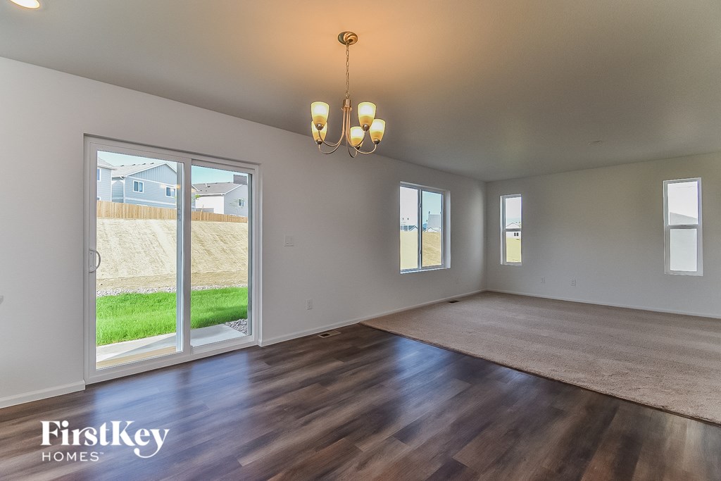 the living room and dining room of a house with wood floors and a large window