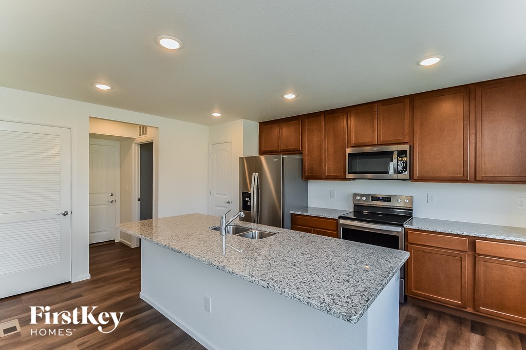 a kitchen with granite counter tops and wooden cabinets