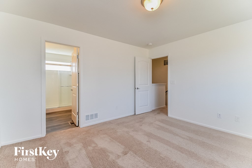 a living room with carpet and a door to a bedroom