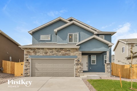 a blue house with a garage door in front of it
