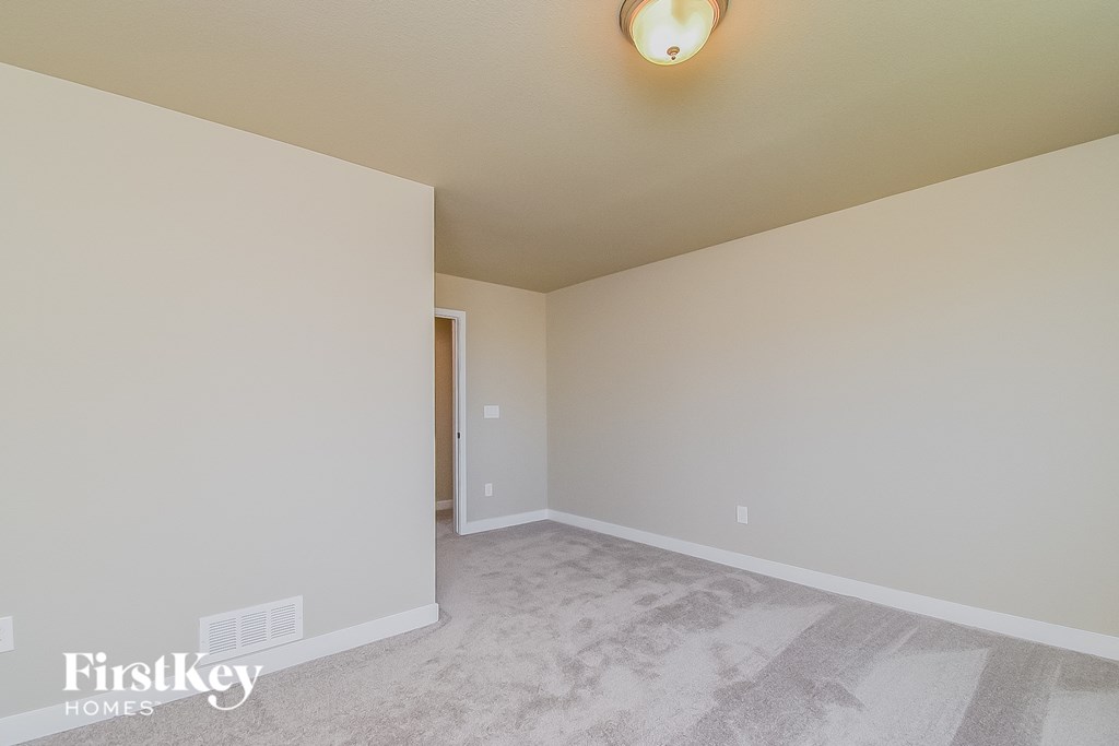 a empty room with a carpeted floor and a white wall