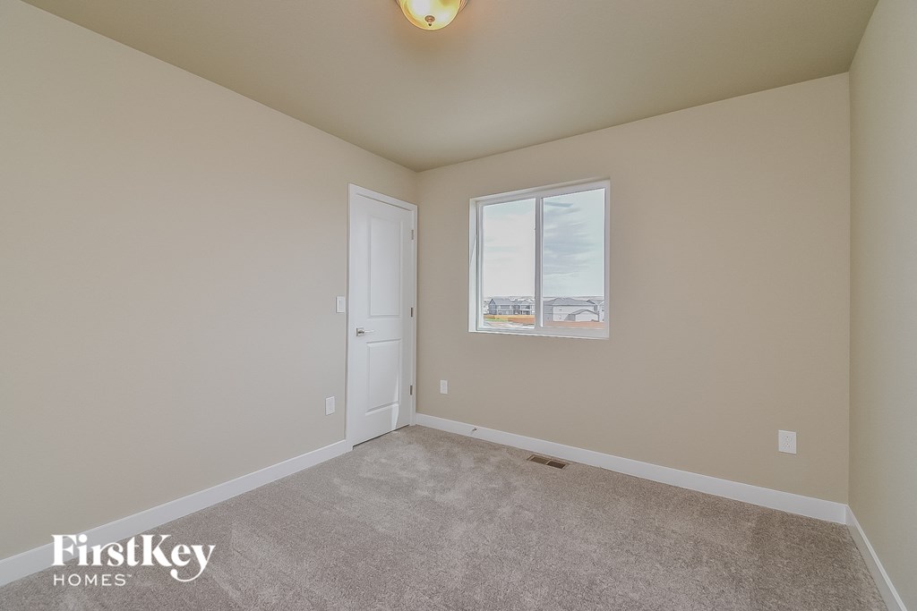 a spacious living room with carpet and a window