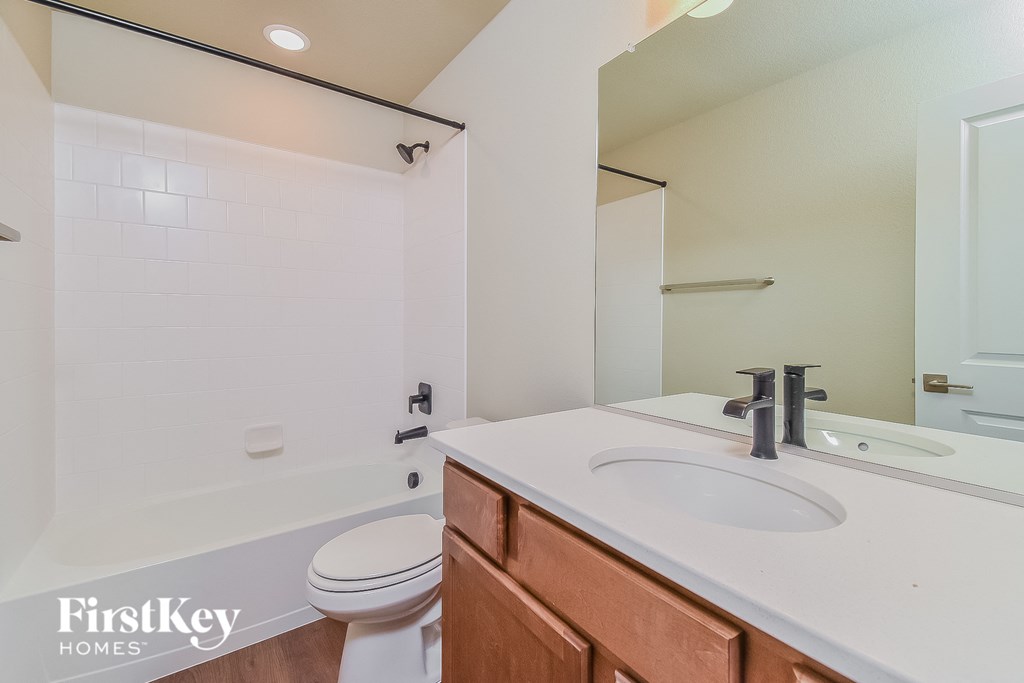 a bathroom with a sink toilet and shower and a mirror