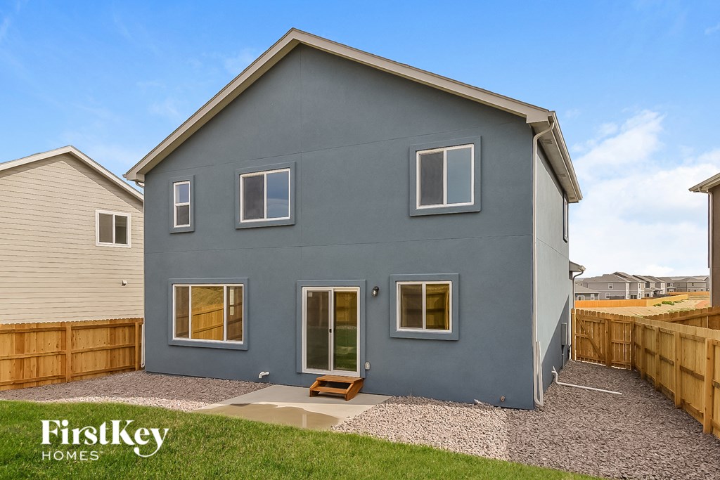 a blue house with a yard and a wooden fence