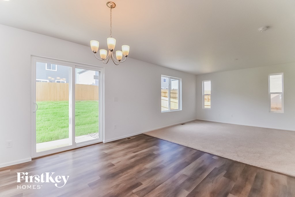 the living room and dining room of a house with wood flooring and a large