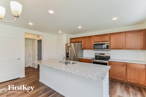 a kitchen with a marble counter top and wooden cabinets