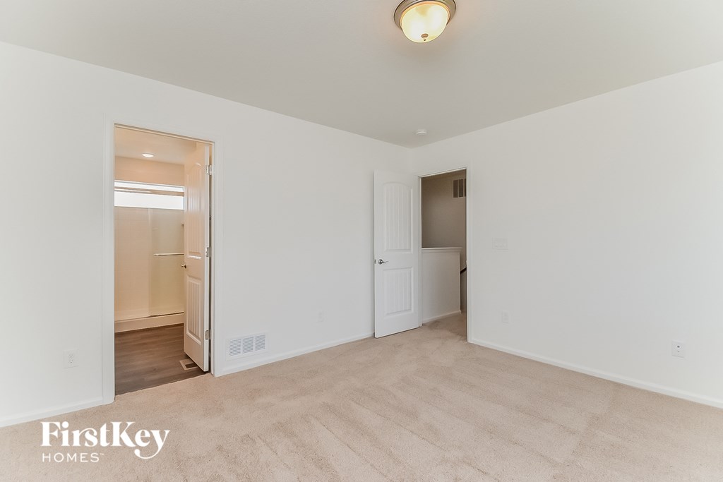 a living room with white walls and a door to a bathroom