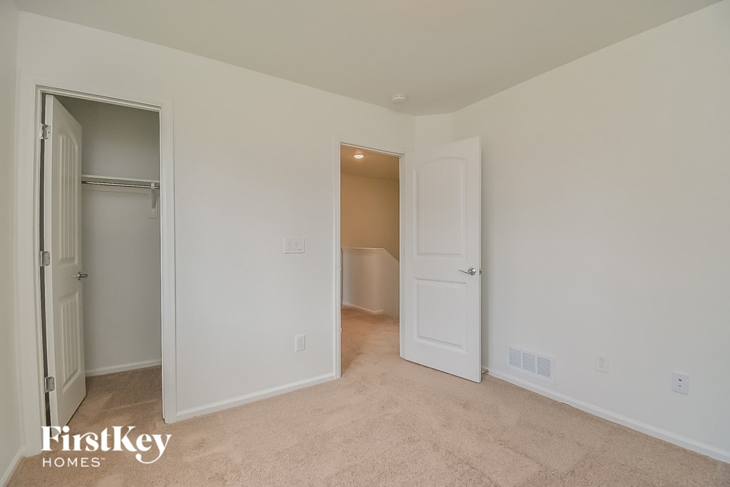 a bedroom with a closet and a door to a bathroom