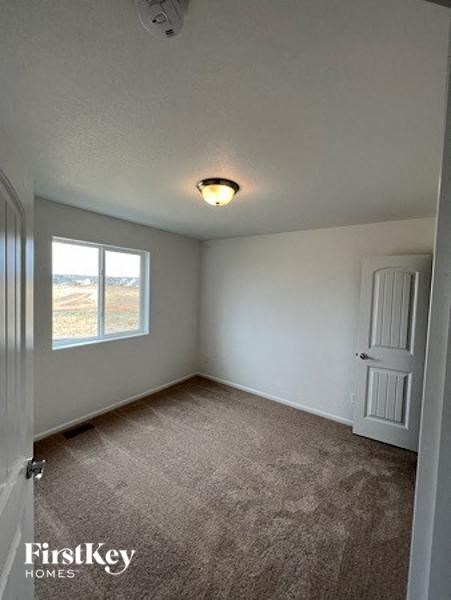 an empty white room with a window and a door