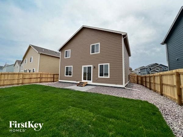 a small house with a yard and a fence