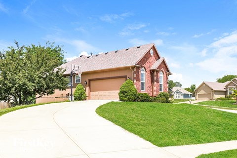 a red brick house with a sidewalk in front of it