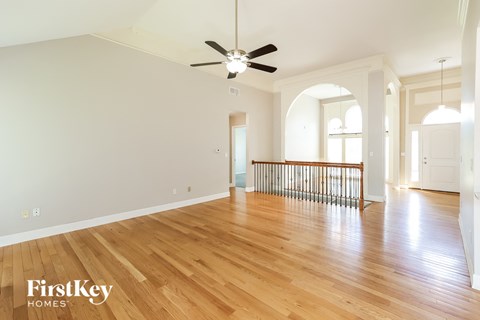 a renovated living room with hardwood floors and a ceiling fan