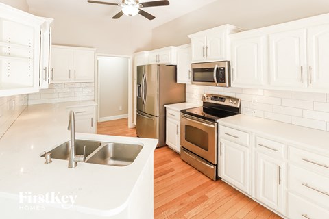 a renovated kitchen with white cabinets and stainless steel appliances