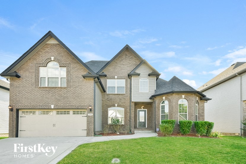 a brick house with a garage and a green lawn