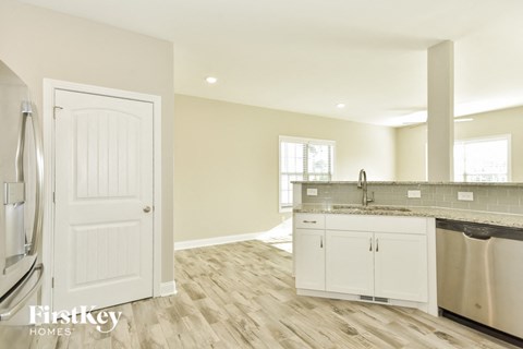 a kitchen with white cabinets and a sink and a refrigerator