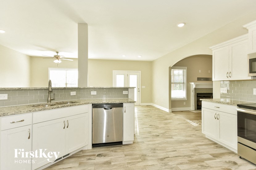 a large kitchen with white cabinets and stainless steel appliances