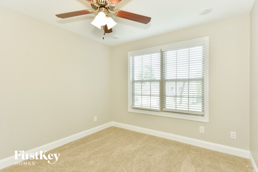 a bedroom with a ceiling fan and a window