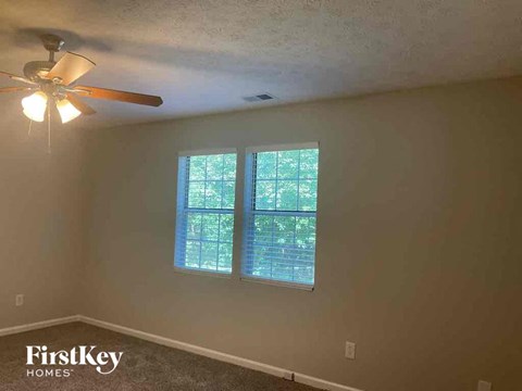a bedroom with a ceiling fan and a window