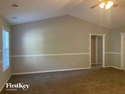 an empty living room with white walls and a ceiling fan
