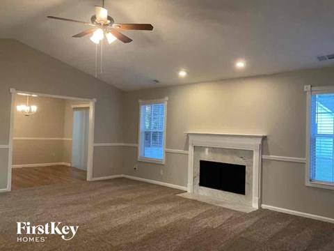 a living room with a fireplace and a ceiling fan