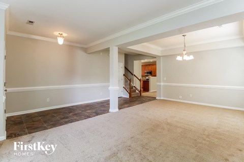 A spacious room with a staircase leading to the upper floor.