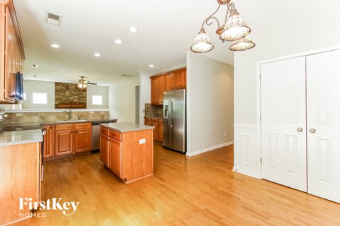 A kitchen with wooden cabinets and a stainless steel refrigerator.