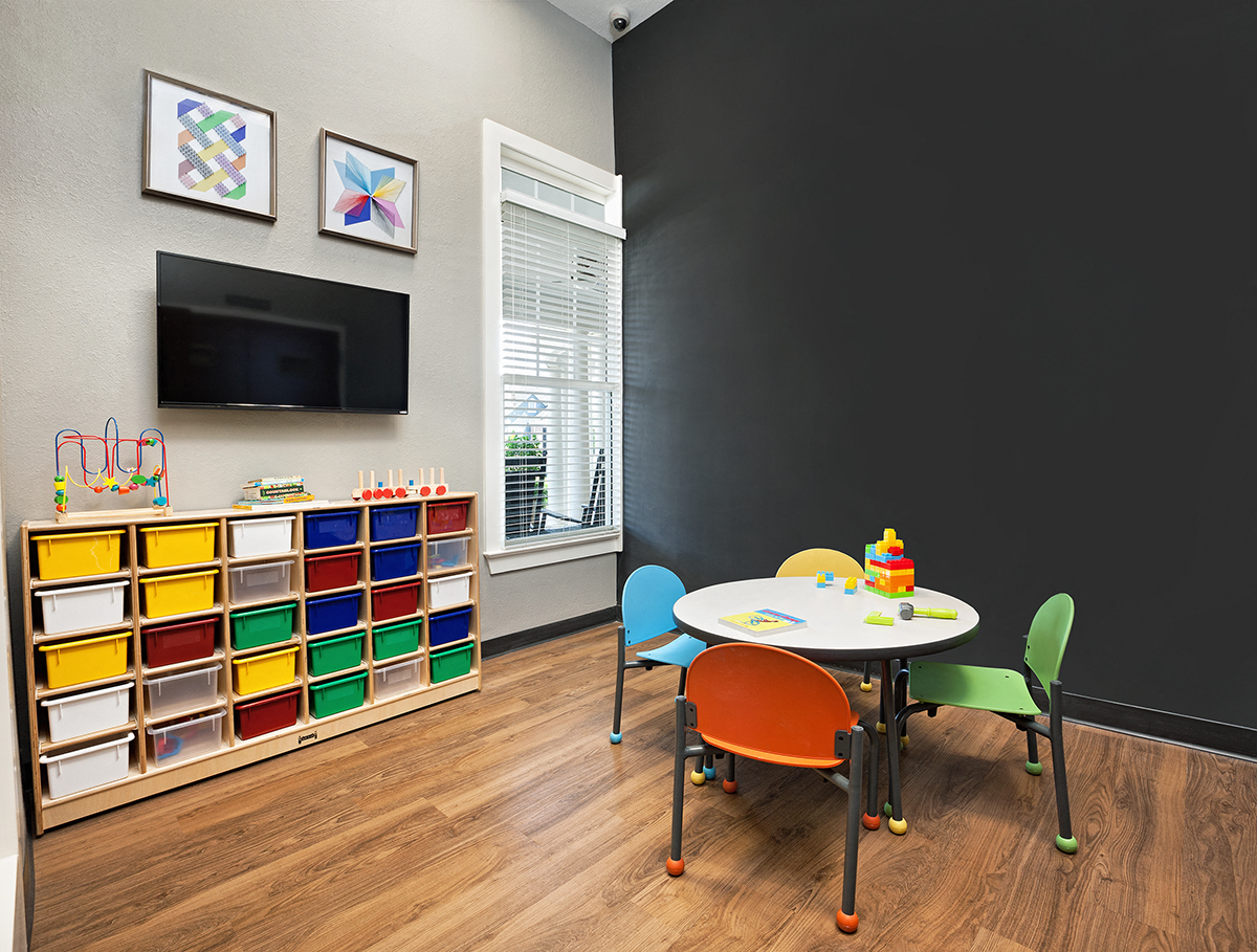 a play room with a table and chairs and a television
