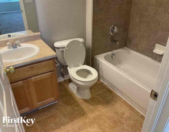 a bathroom with a toilet and a tub and a sink