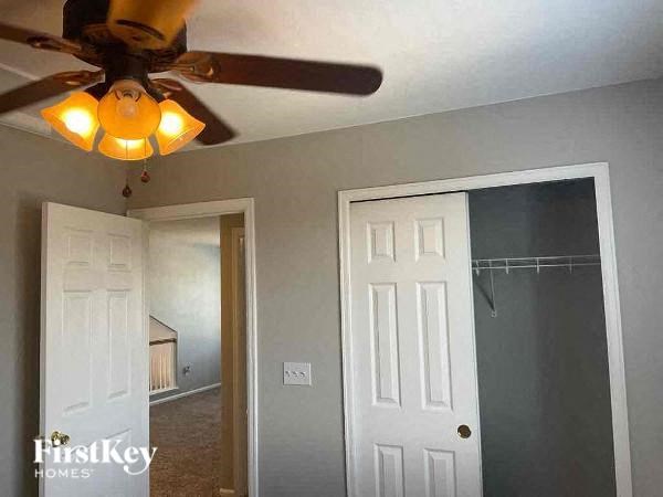a living room with a ceiling fan and a closet