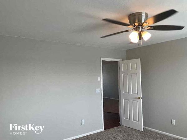 a bedroom with a ceiling fan and a door