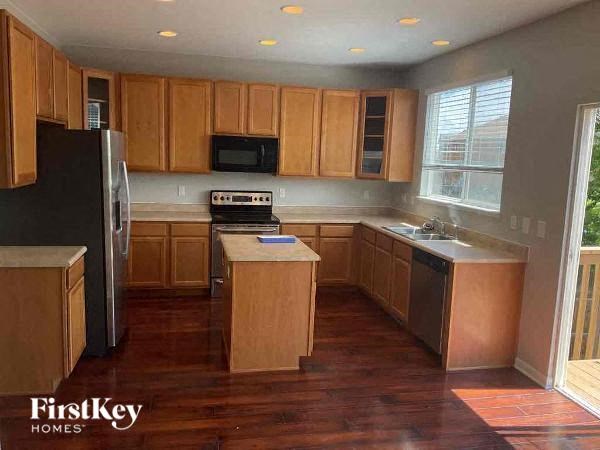 a kitchen with wooden cabinets and a black refrigerator