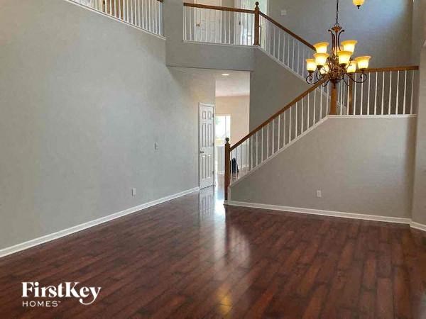 a living room with a staircase and a wood floor