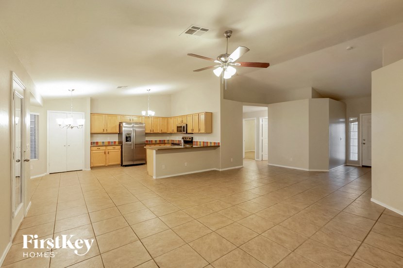 an empty kitchen and living room with a ceiling fan