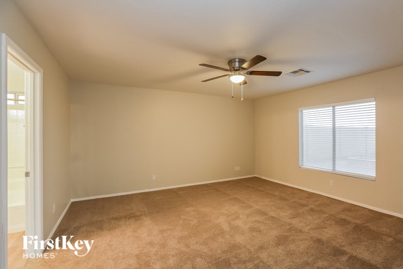 a empty room with a ceiling fan and a window