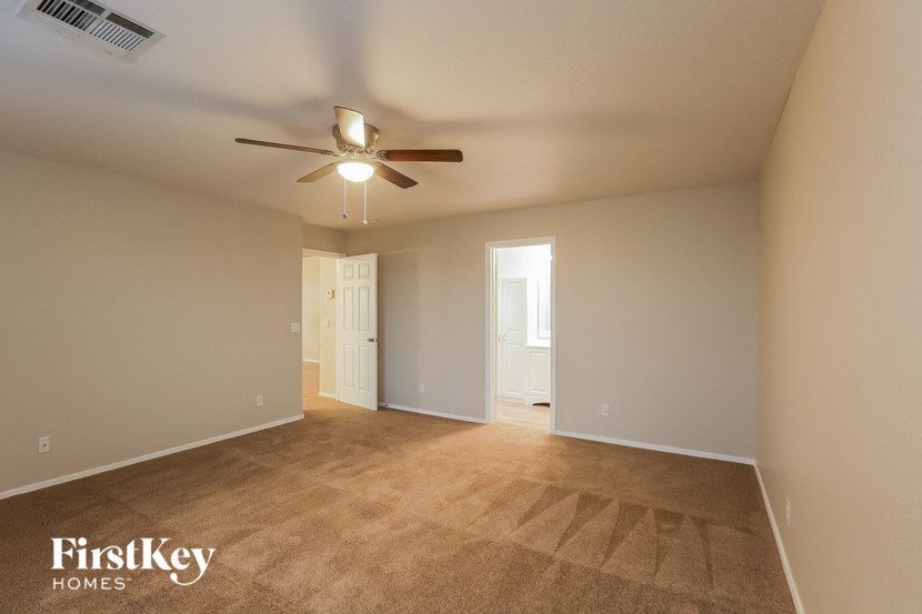 a living room with carpet and a ceiling fan